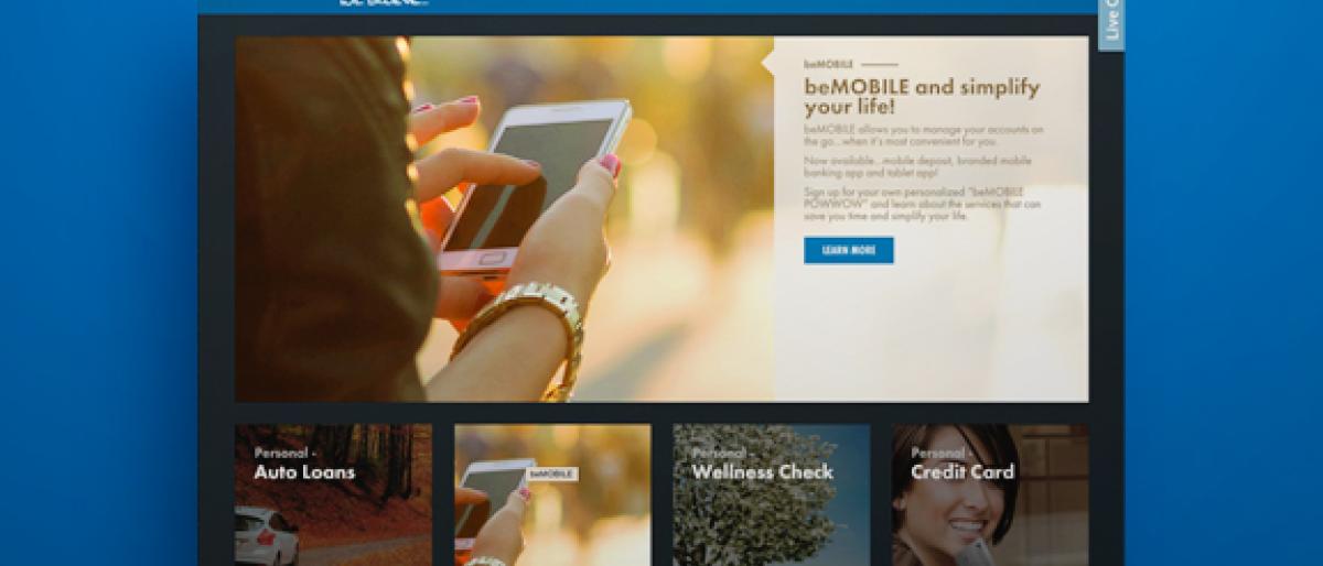 Kohler Credit Union website homepage showing a hand holding a phone for mobile banking