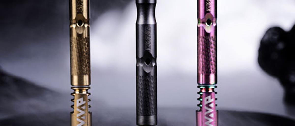 Three DynaVap vaporizer pens in black, gold, and pink finishes against a smoky backdrop