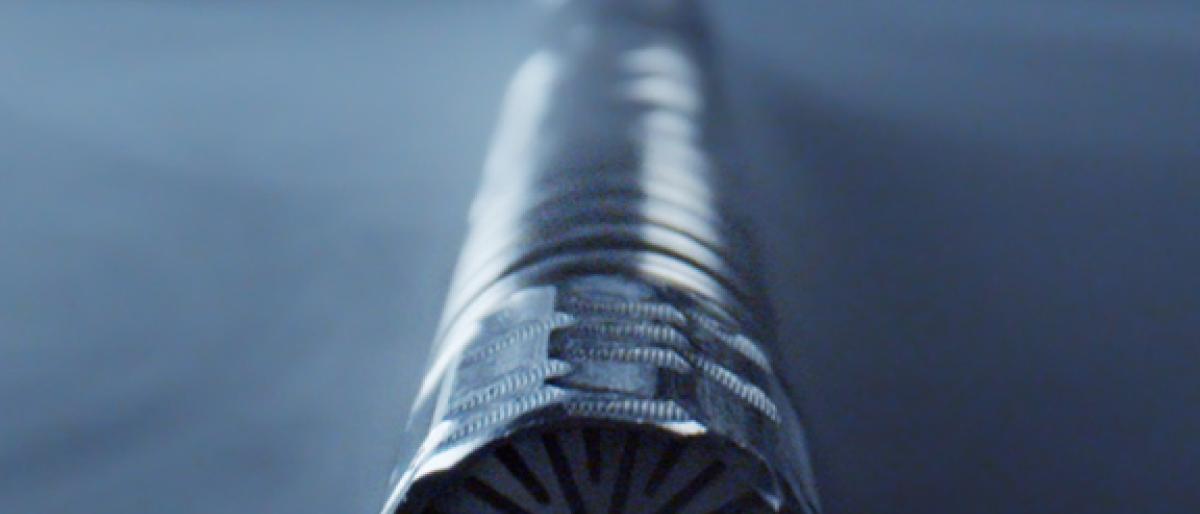 Close-up of a textured metal vaporizer tip against a dark blue background