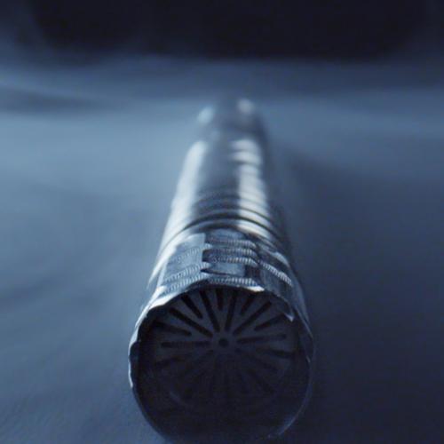 Close-up of a textured metal vaporizer tip against a dark blue background