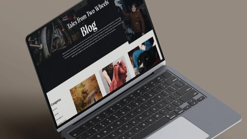 Laptop showing a motorcycle gear blog page titled Tales from Two Wheels